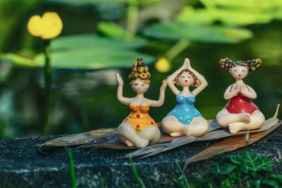 Drei sitzede Figuren, die Yoga praktizieren